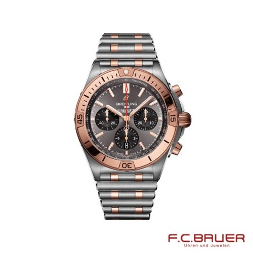 Die Breitling - Chronomat B01 42 ub0134101b1u1-9793941 ist eine Chronographen-Armbanduhr mit einer Mischung aus Edelstahl und Roségold-Akzenten. Sie verfügt über ein schwarzes Zifferblatt, drei Hilfszifferblätter und leuchtende Zeiger. Das Markenlogo ist oben prominent angebracht, in der unteren rechten Ecke ist elegant „Juwelier Bauer, München“ eingraviert.