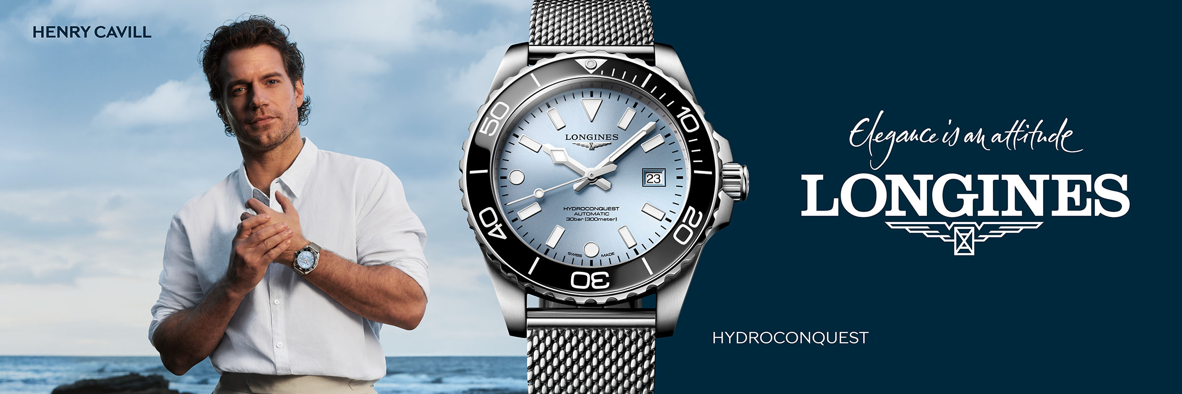 Ein Mann in einem weißen Hemd steht am Meer und trägt eine silberne Longines HydroConquest Uhr. Neben ihm steht der Text: "Eleganz ist eine Haltung. LONGINES. HYDROCONQUEST." Das Markenlogo ist zu sehen.